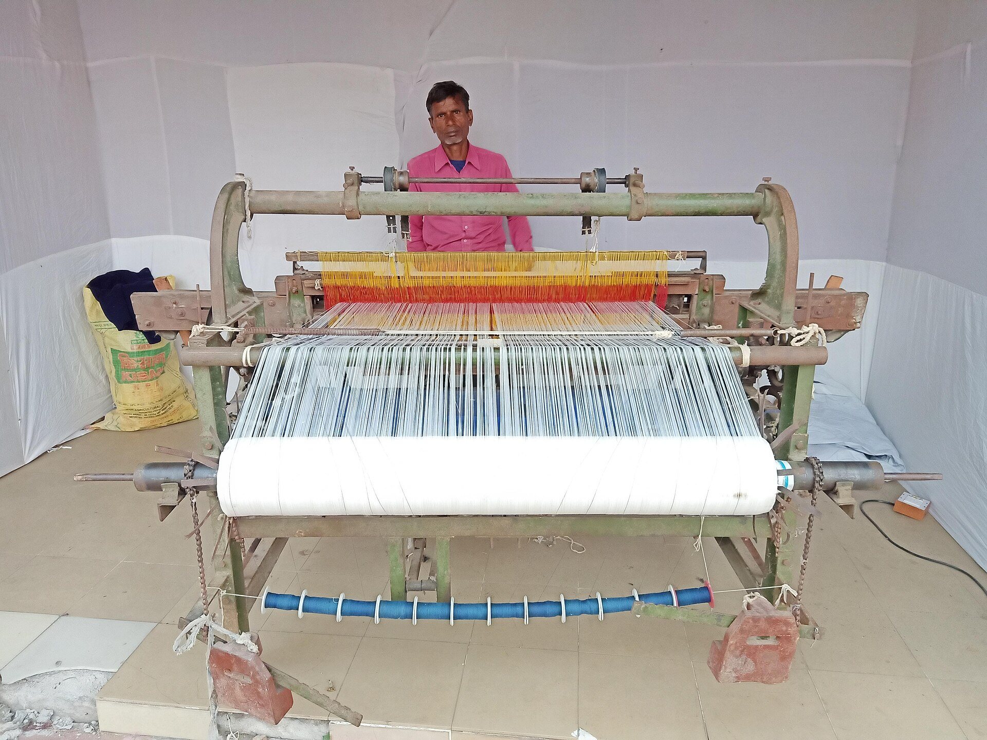 Master weaver operating traditional pit handloom weaving fine silk