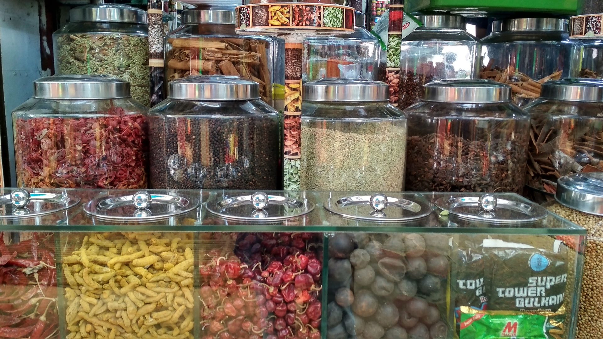 Aromatic mountain of Indian culinary spices, star anise, turmeric, and cardamoms displayed in brass bowls