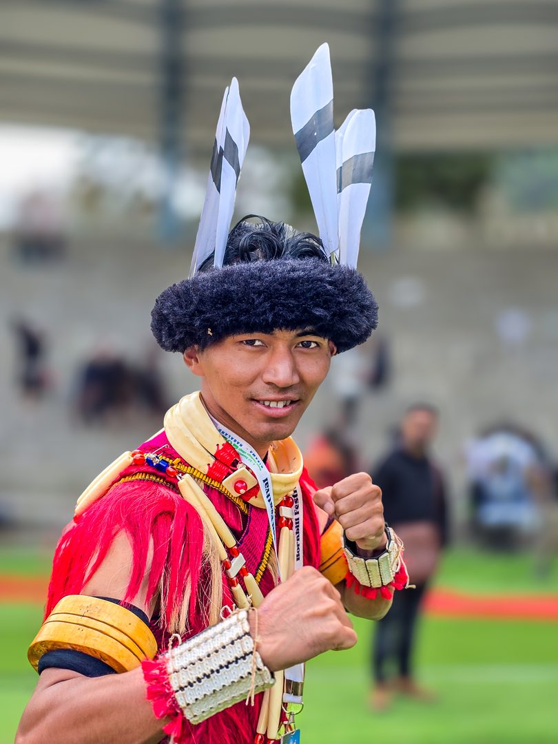 Naga tribal elder in traditional ceremonial feathered headdress and beaded necklace during Hornbill Festival in Nagaland