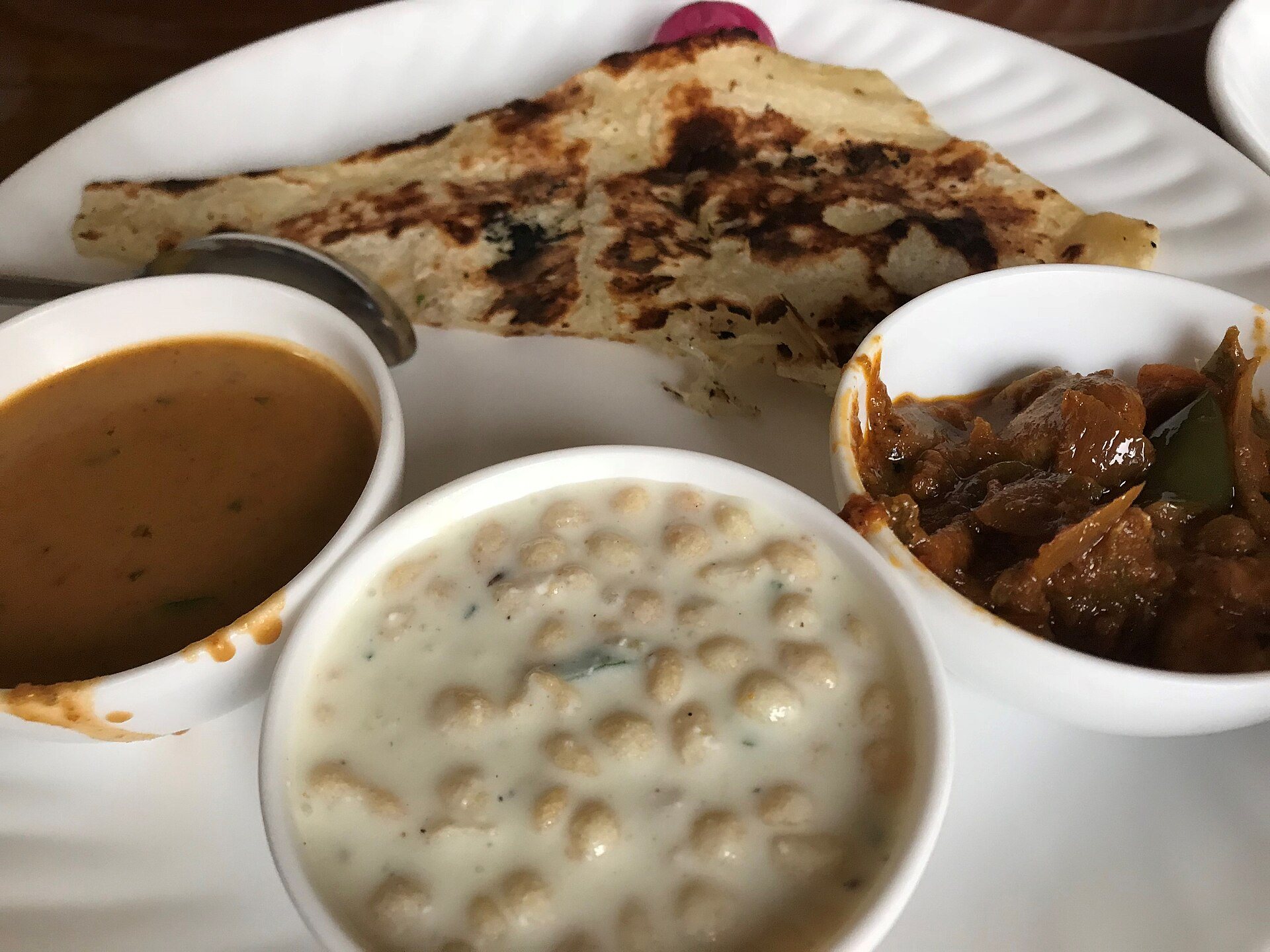 A traditional copper Indian thali with balanced brass katoris holding seasonal lentils, vegetables, and rice