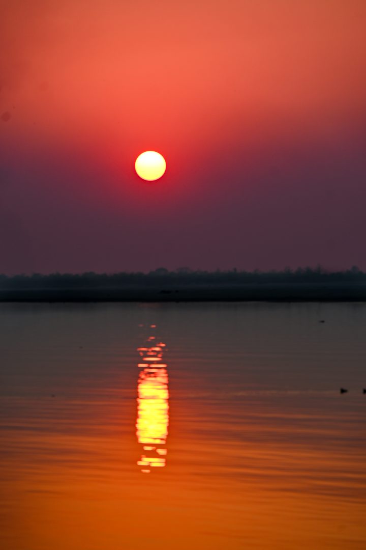 Tranquil waters of the Brahmaputra River around Majuli island at sunset