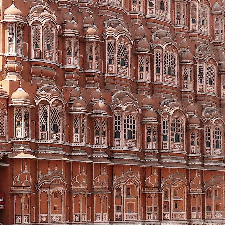 Intricate honeycombed pink sandstone facade of Hawa Mahal in Jaipur