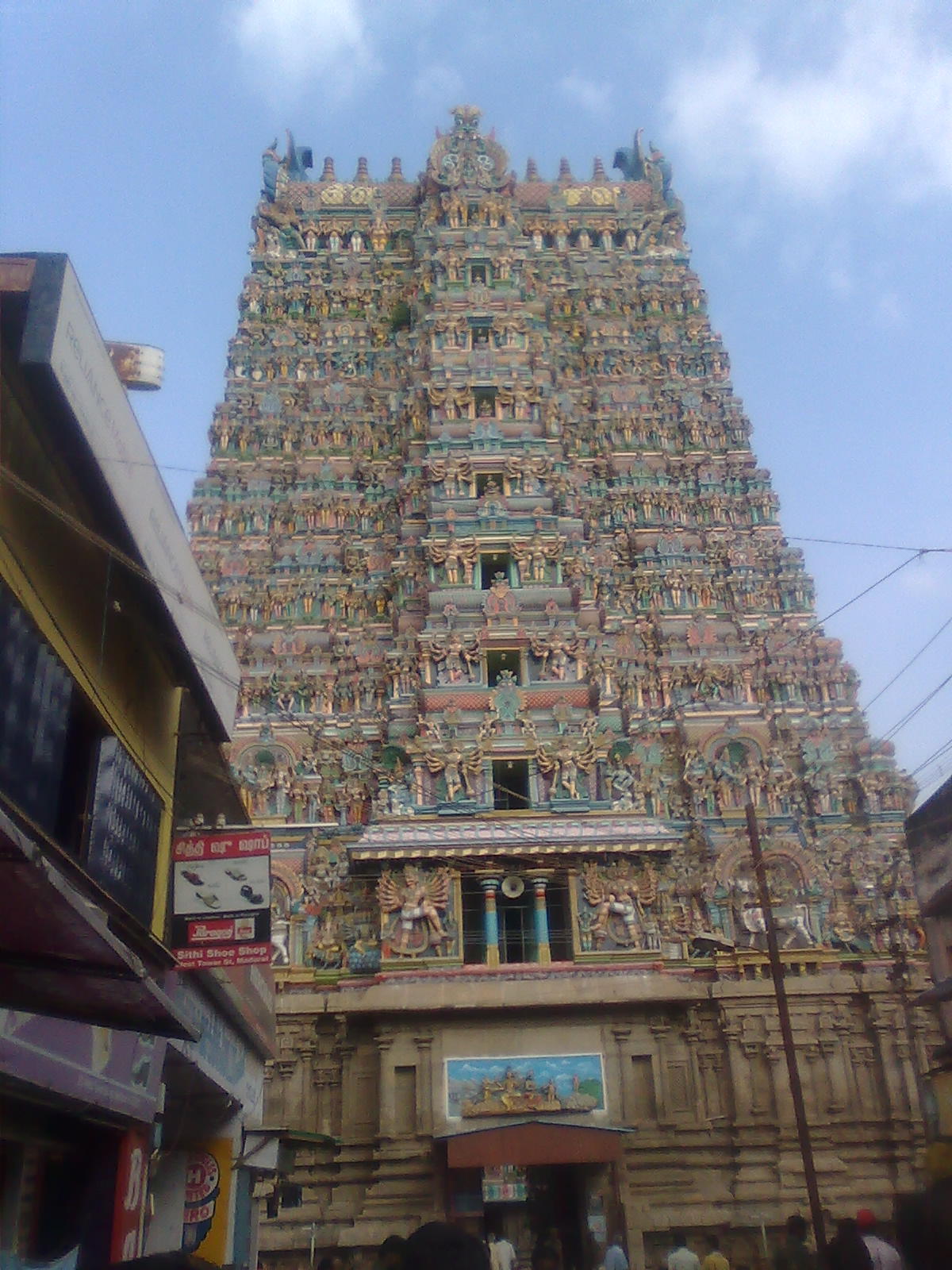 Soaring multi-tiered Dravidian granite temple gopuram adorned with sculpted deities in Tamil Nadu