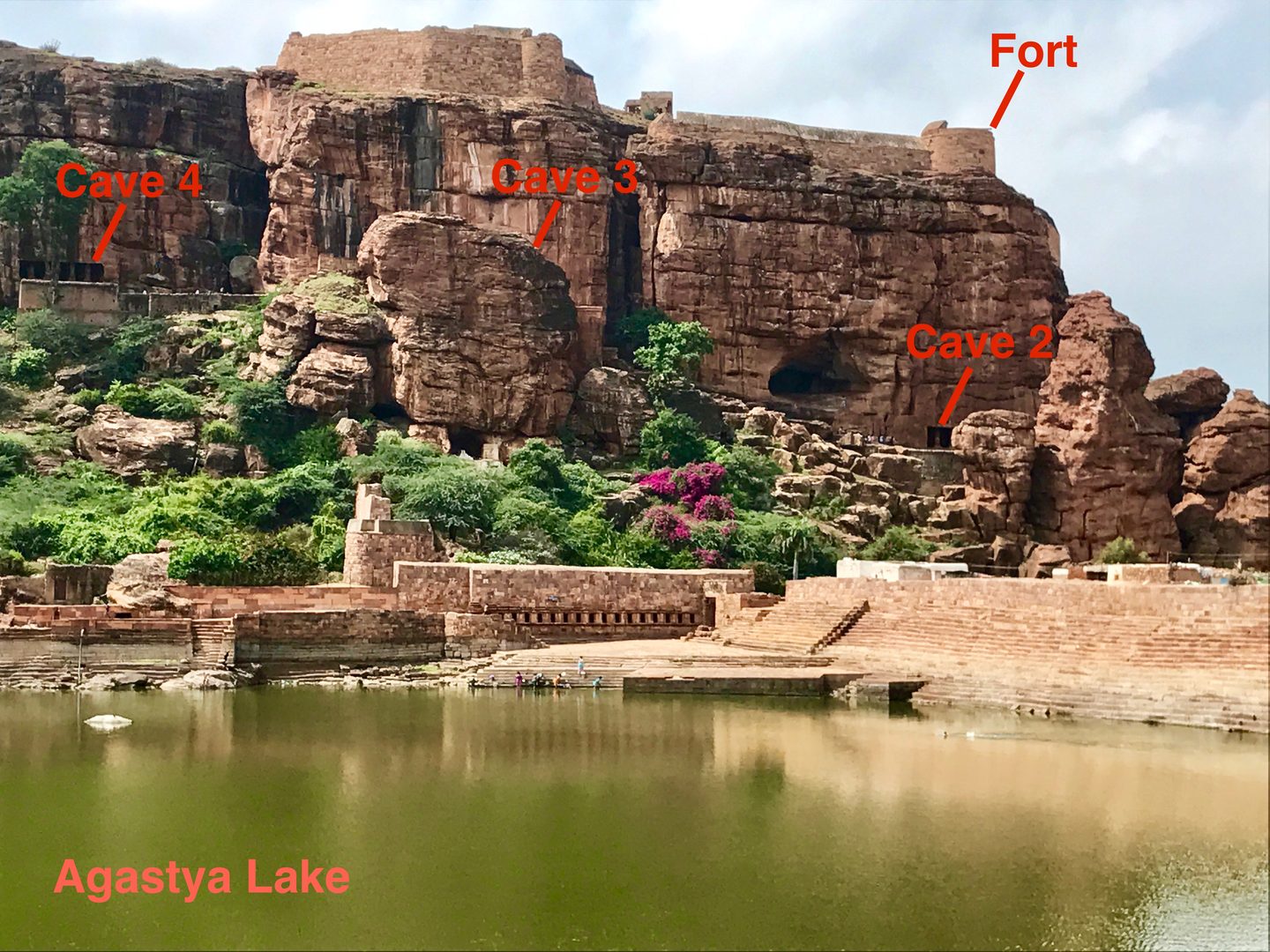Weathered ancient rock-cut sandstone cave temples overlooking Agastya lake in Badami