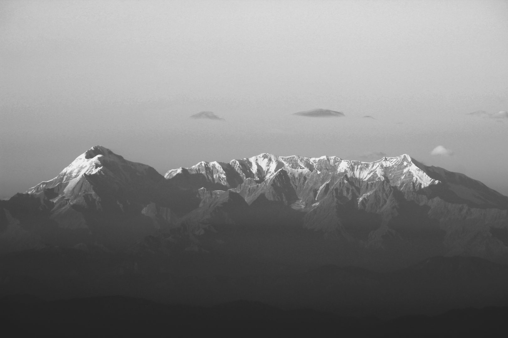 Sunset glowing behind snow-capped Himalayan peaks and alpine valleys
