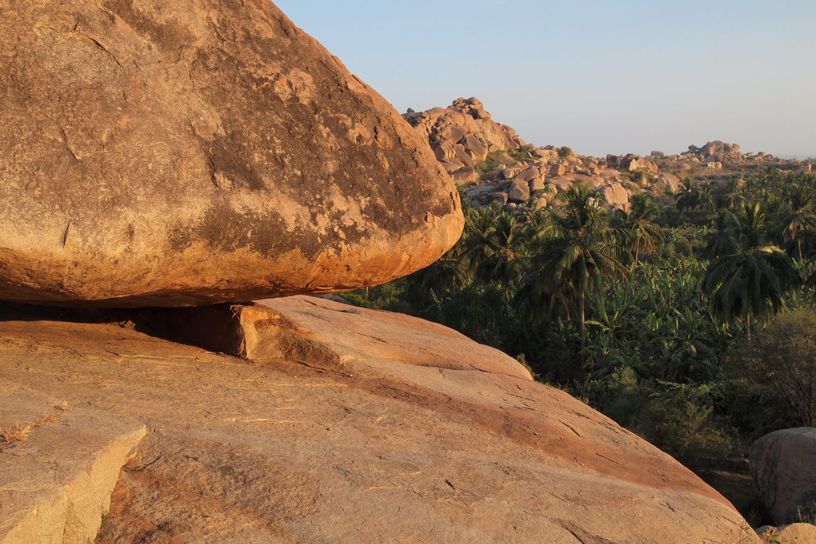 Dramatic golden hour across ancient boulder-strewn landscape and ruins of Hampi
