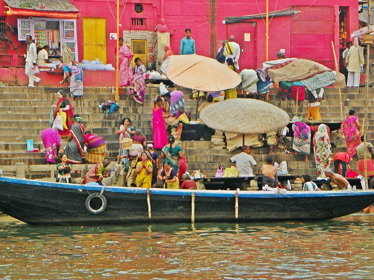 A devotee offering morning river water libation facing the rising sun