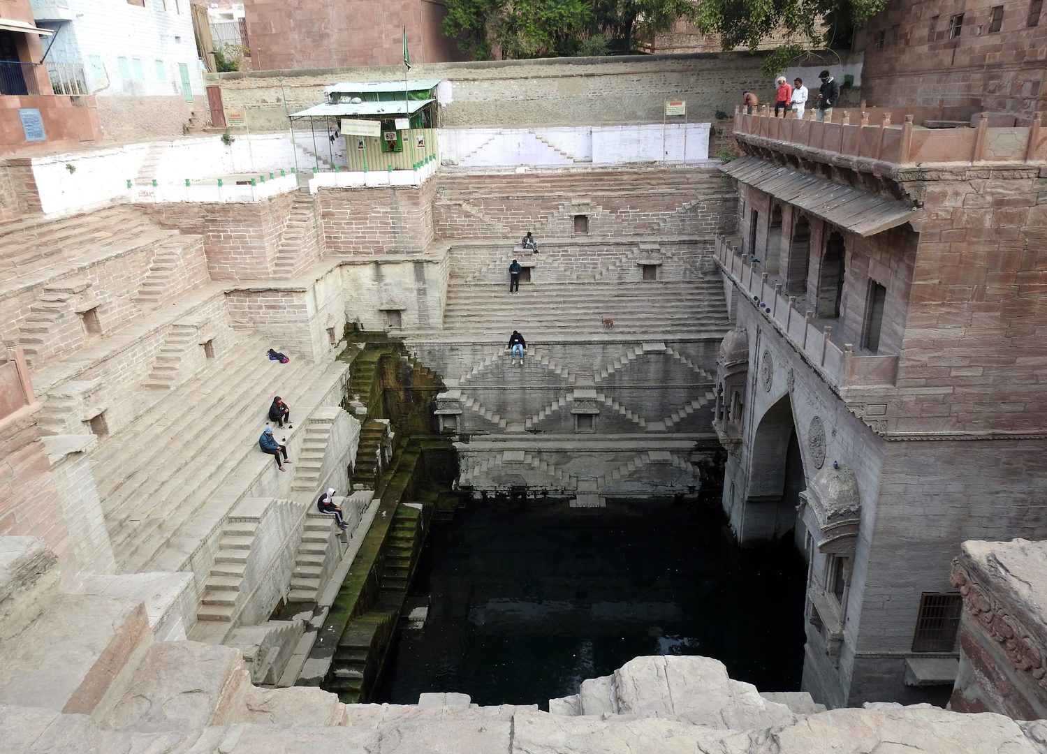 Historic red sandstone Toorji Ka Jhalra stepwell carved with ornate lion heads in Jodhpur