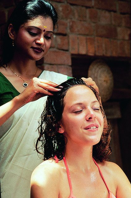 Traditional Kerala Ayurvedic wellness therapy with herbal medicated oils and brass vessel