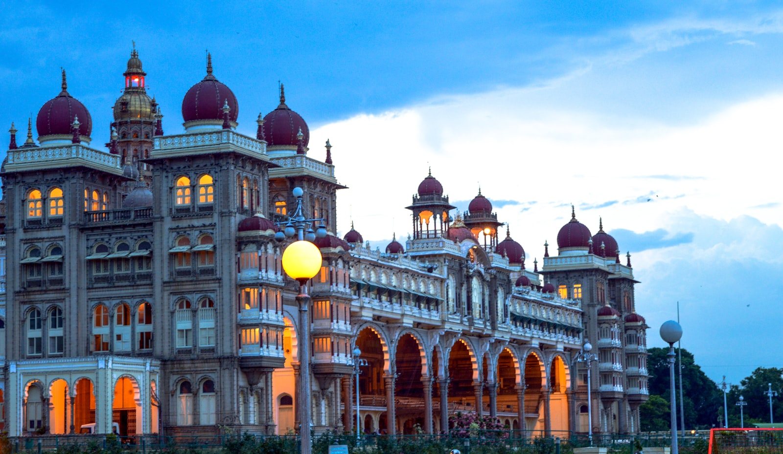 Illuminated facade of Mysore Palace glowing against deep twilight sky