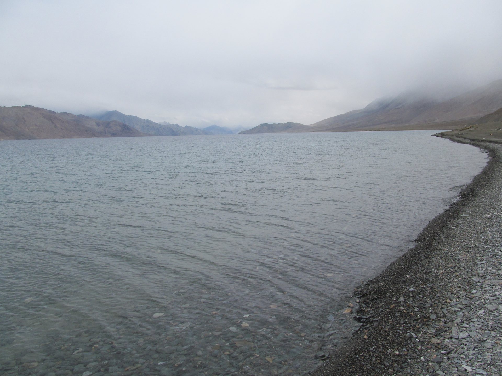Intense cobalt blue waters of Pangong Tso lake reflecting barren desert mountains