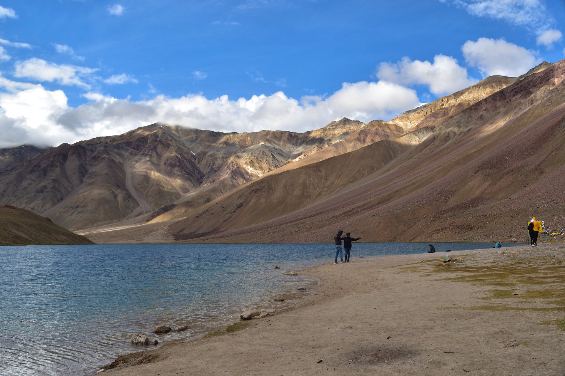Crescent-shaped emerald waters of Chandratal Lake against scree mountains in Spiti