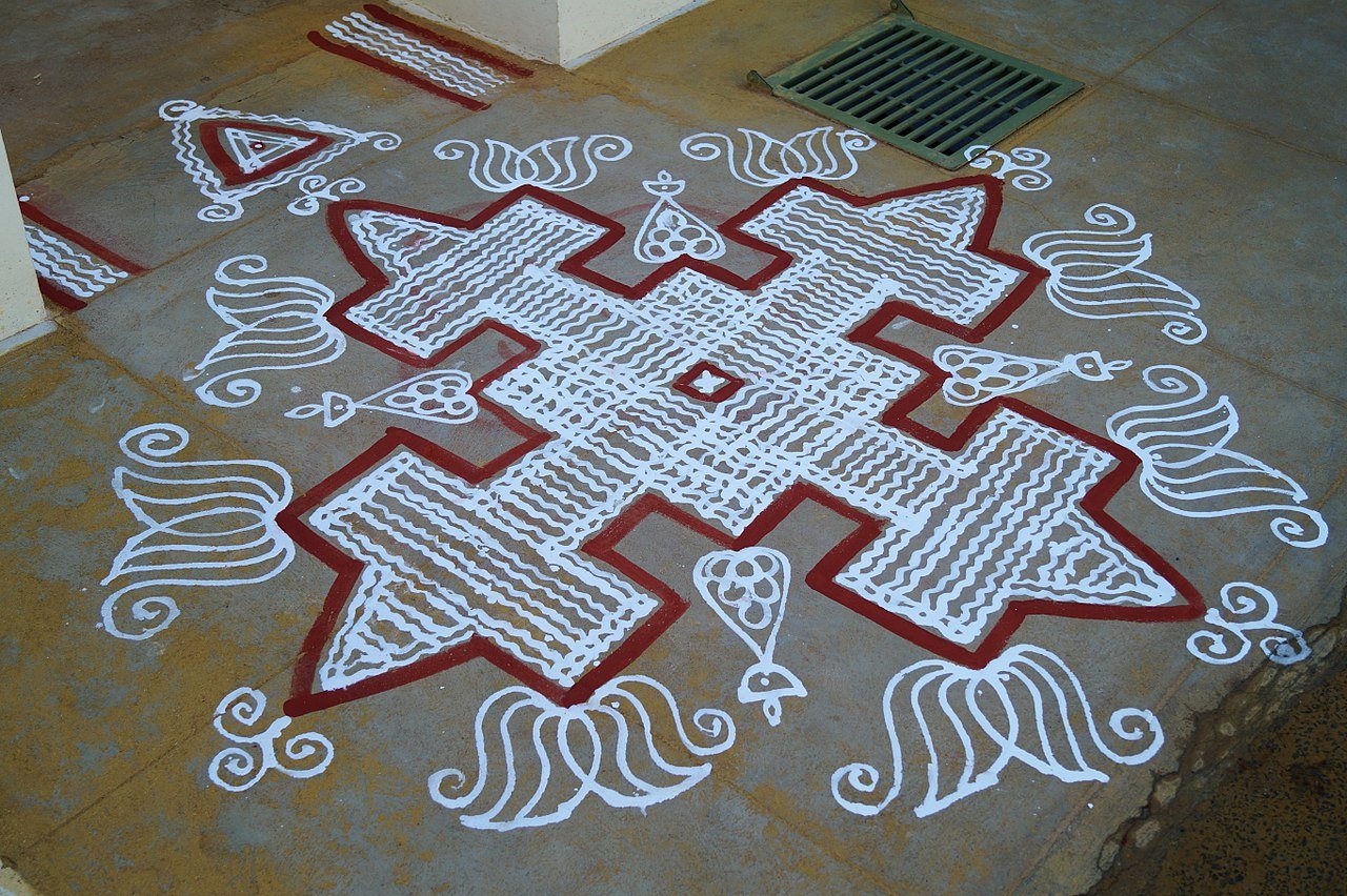 Intricate sacred geometric kolam design drawn in edible white rice flour on home threshold