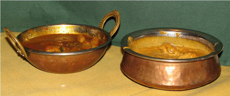 Traditional Indian unglazed terracotta handi pot simmering over embers