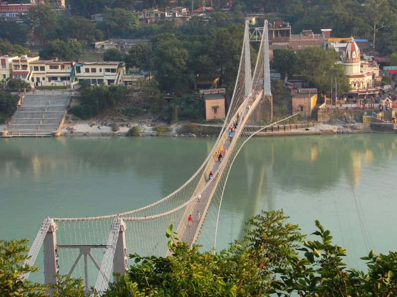 Suspension bridge spanning the emerald green Ganges river in Rishikesh