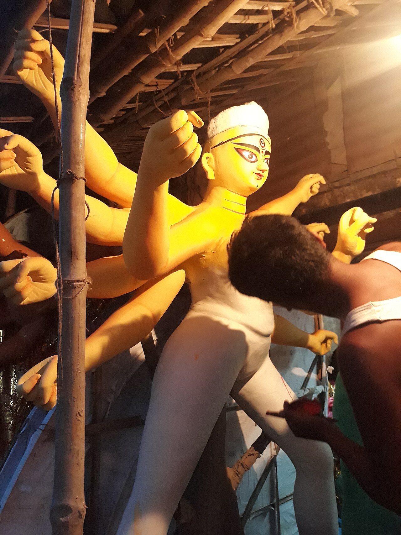 Master sculptor shaping sacred clay Durga idol in Kumartuli artisan studio