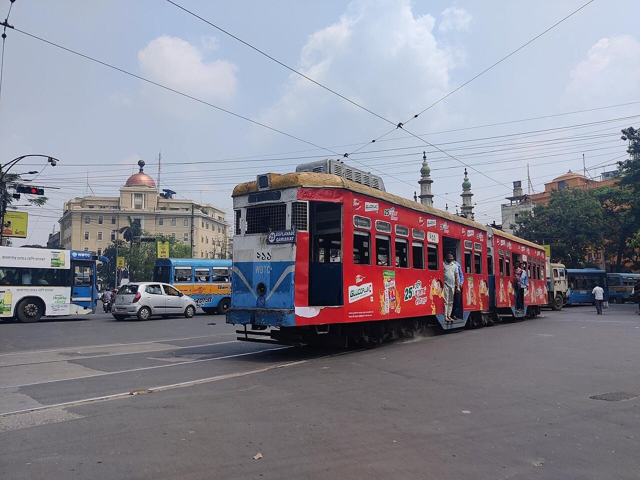 Vintage red and cream electric tramcar navigating the historic streets of College Street, Kolkata