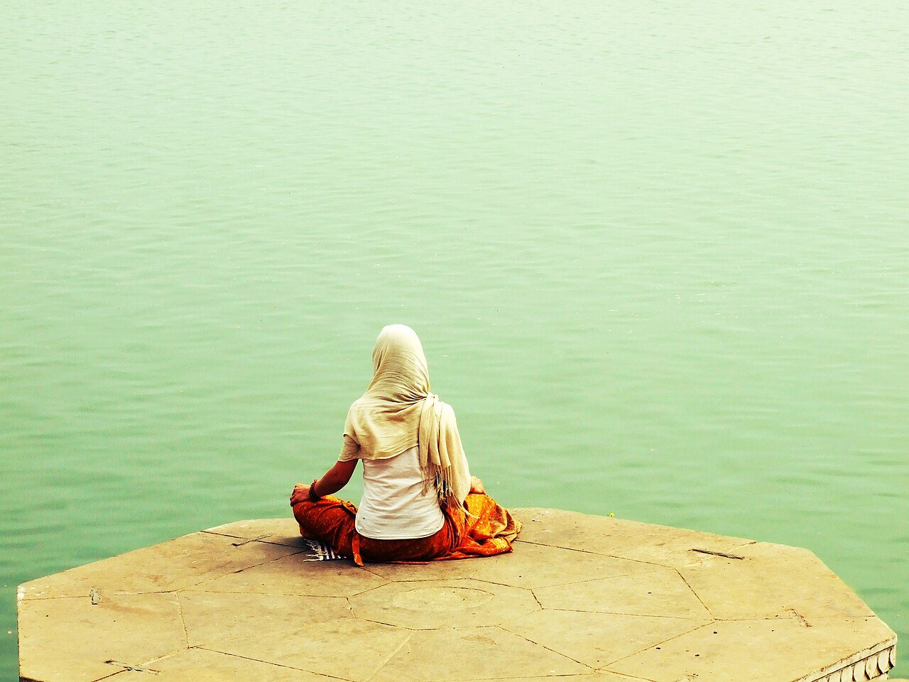 A contemplative scene of quiet meditation along the riverbank in morning light
