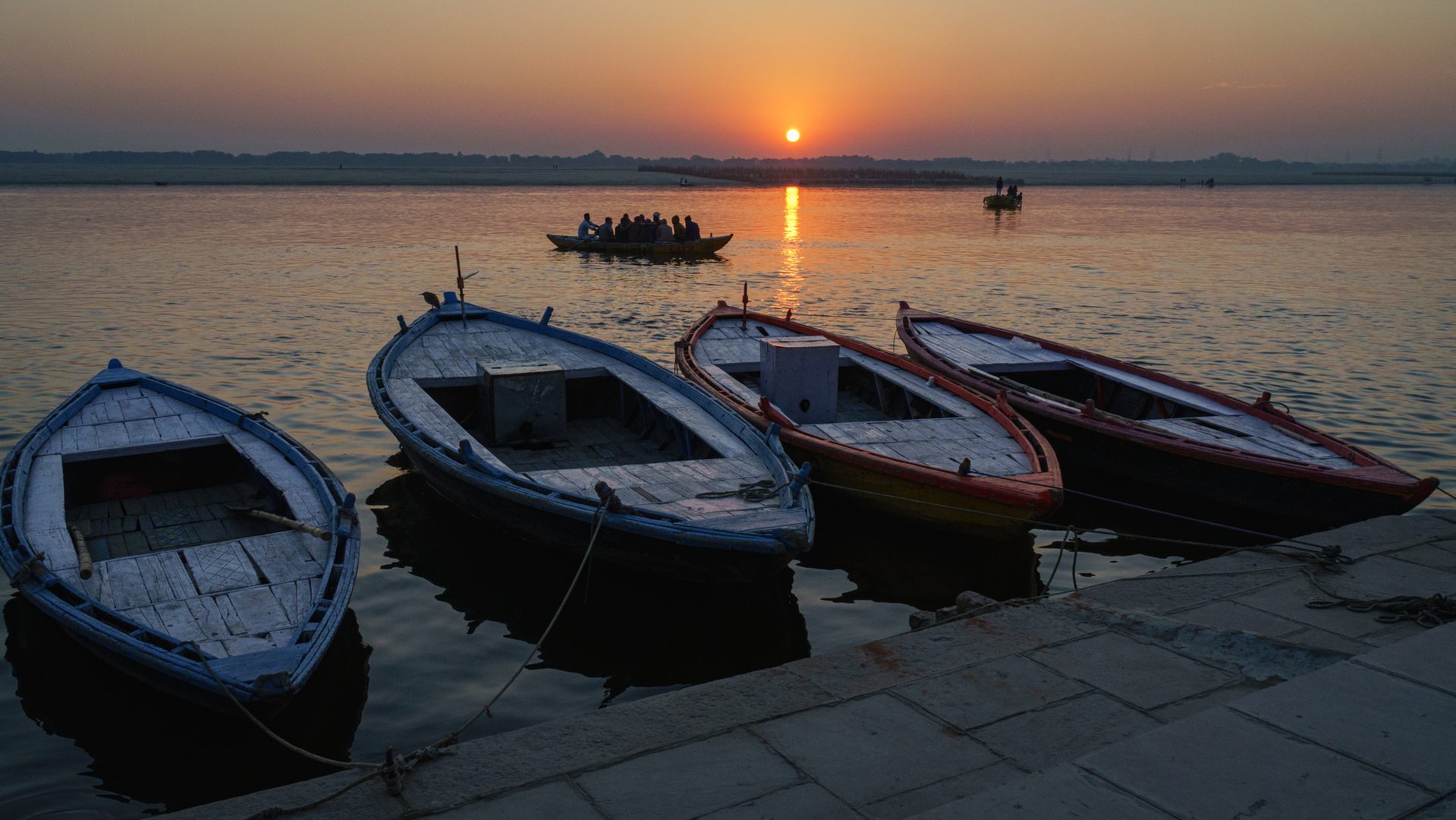 Silhouette of an Indian boatman gently rowing a wooden craft across the mist-shrouded river Ganga at dawn
